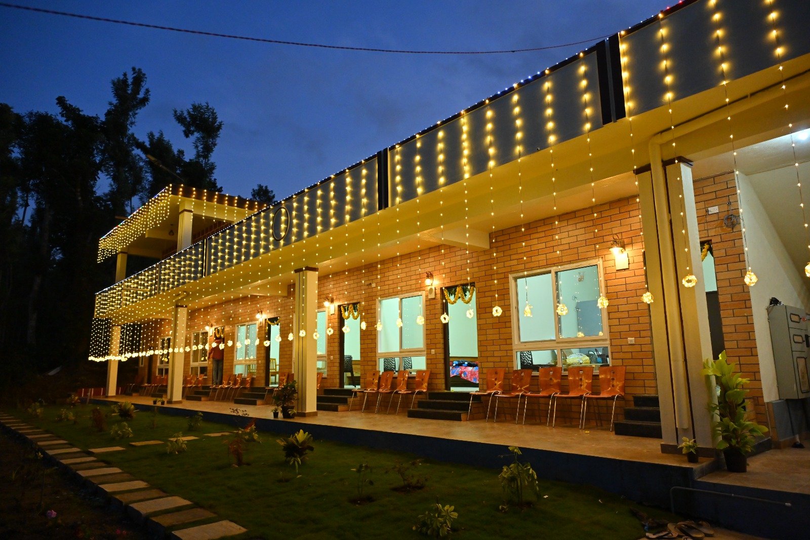 Homestay facade glowing with lights after sunset